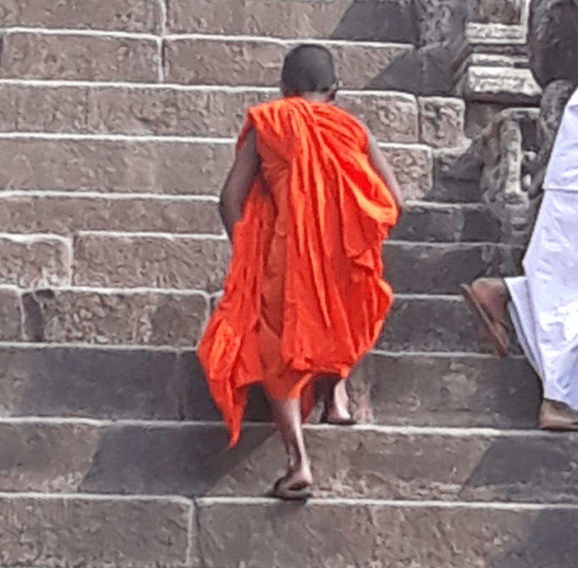 Ein junger Mönch auf einer Treppe